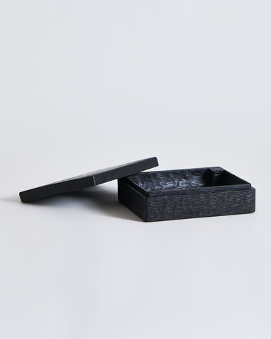 Black rectangular, wooden box with lid by Ryuji Mitani on a light gray background
