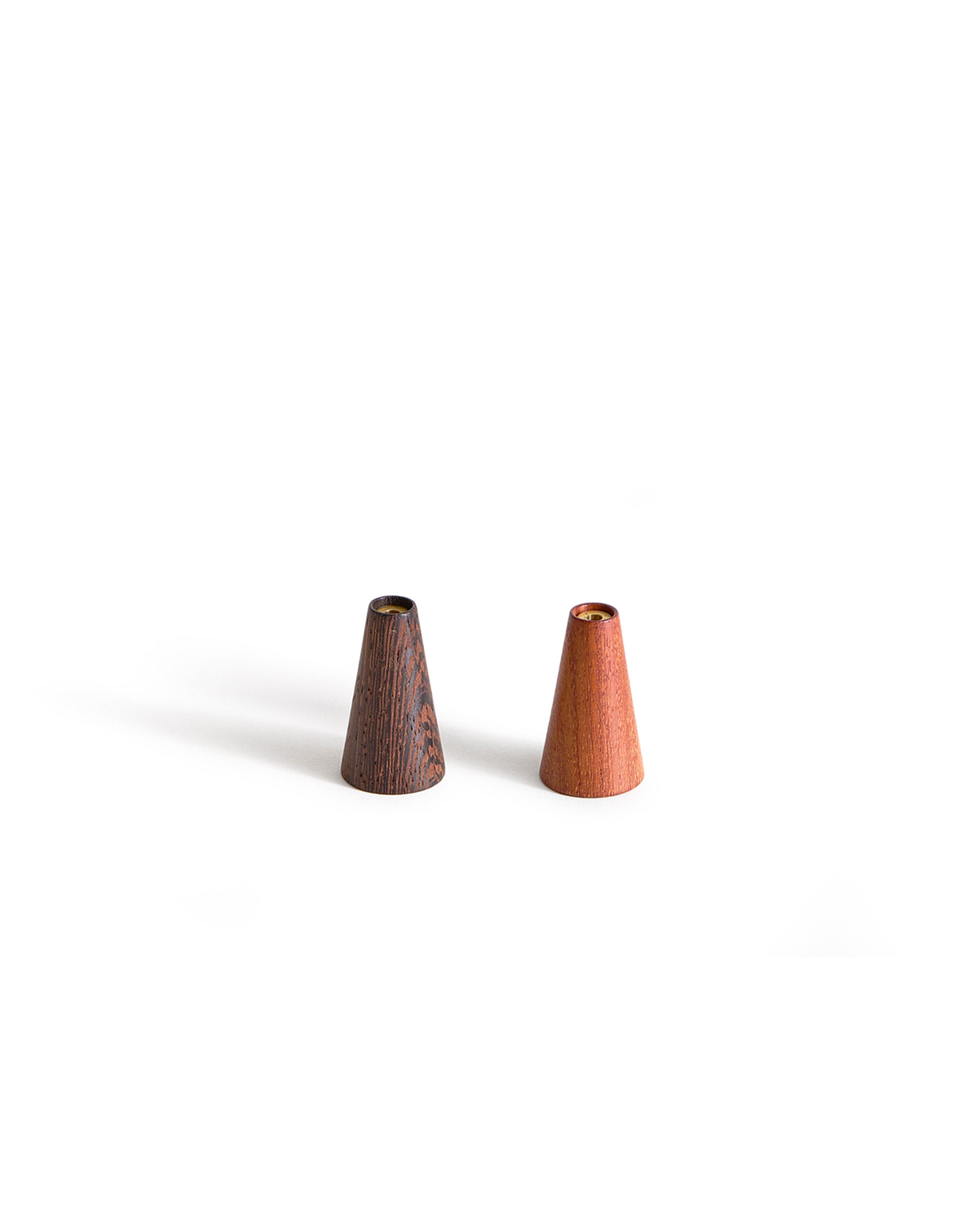 Two small wooden cone-shaped incense holders on a white background