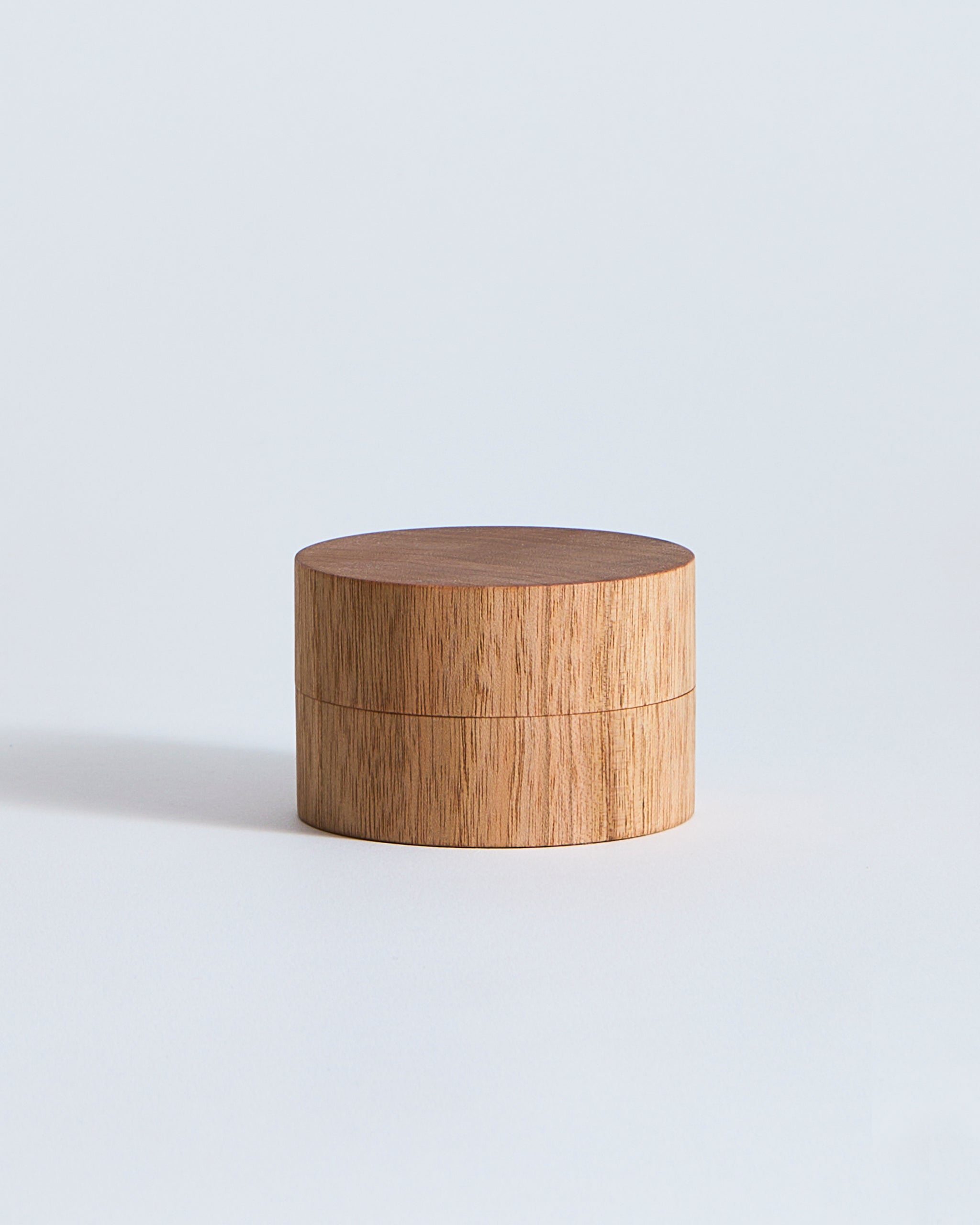 Wooden cylindrical container by Ryuji Mitani on a light gray background