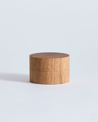 Wooden cylindrical container by Ryuji Mitani on a light gray background
