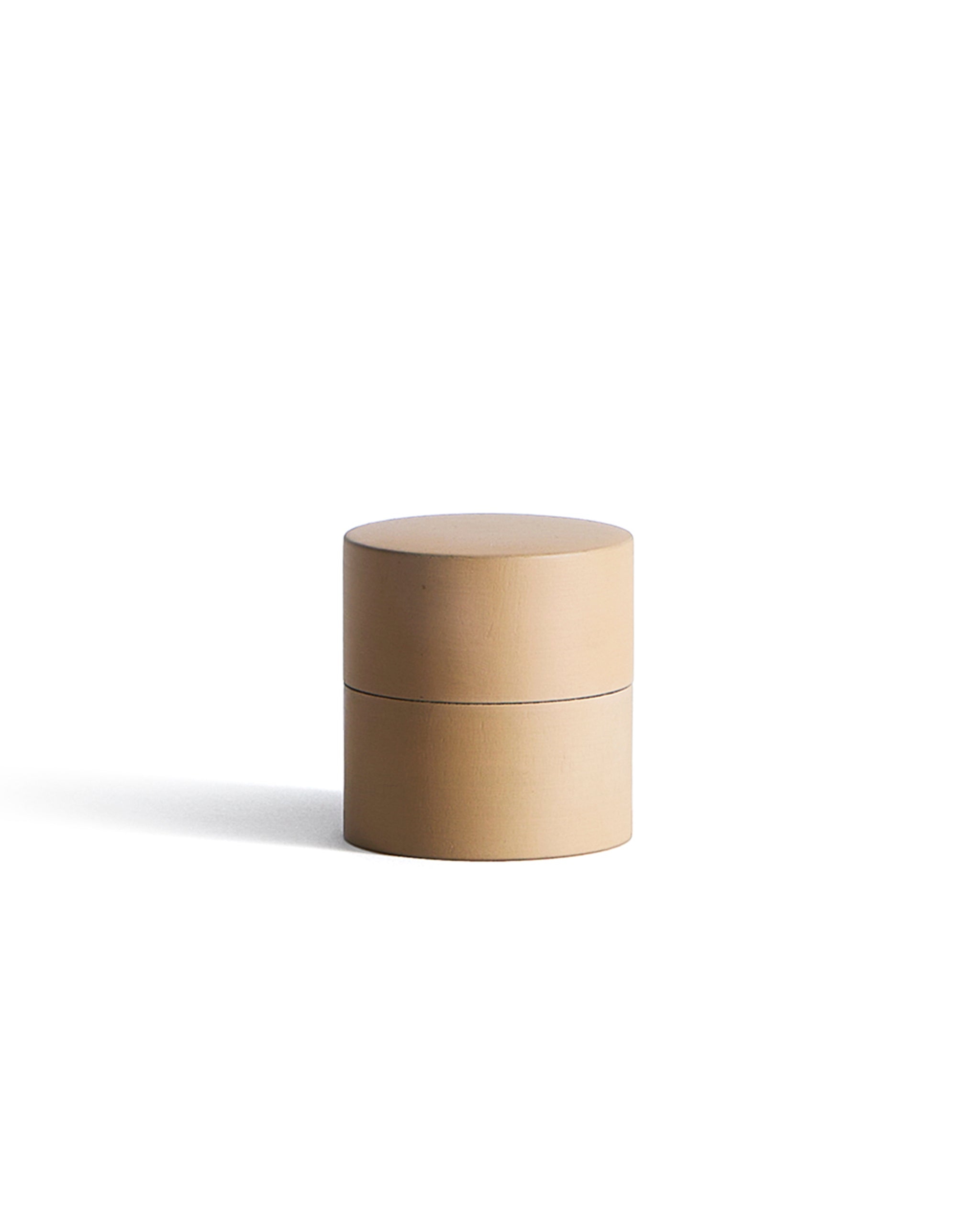 Beige cylindrical container by Ryuji Mitani on a white background
