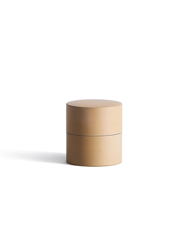 Beige cylindrical container by Ryuji Mitani on a white background