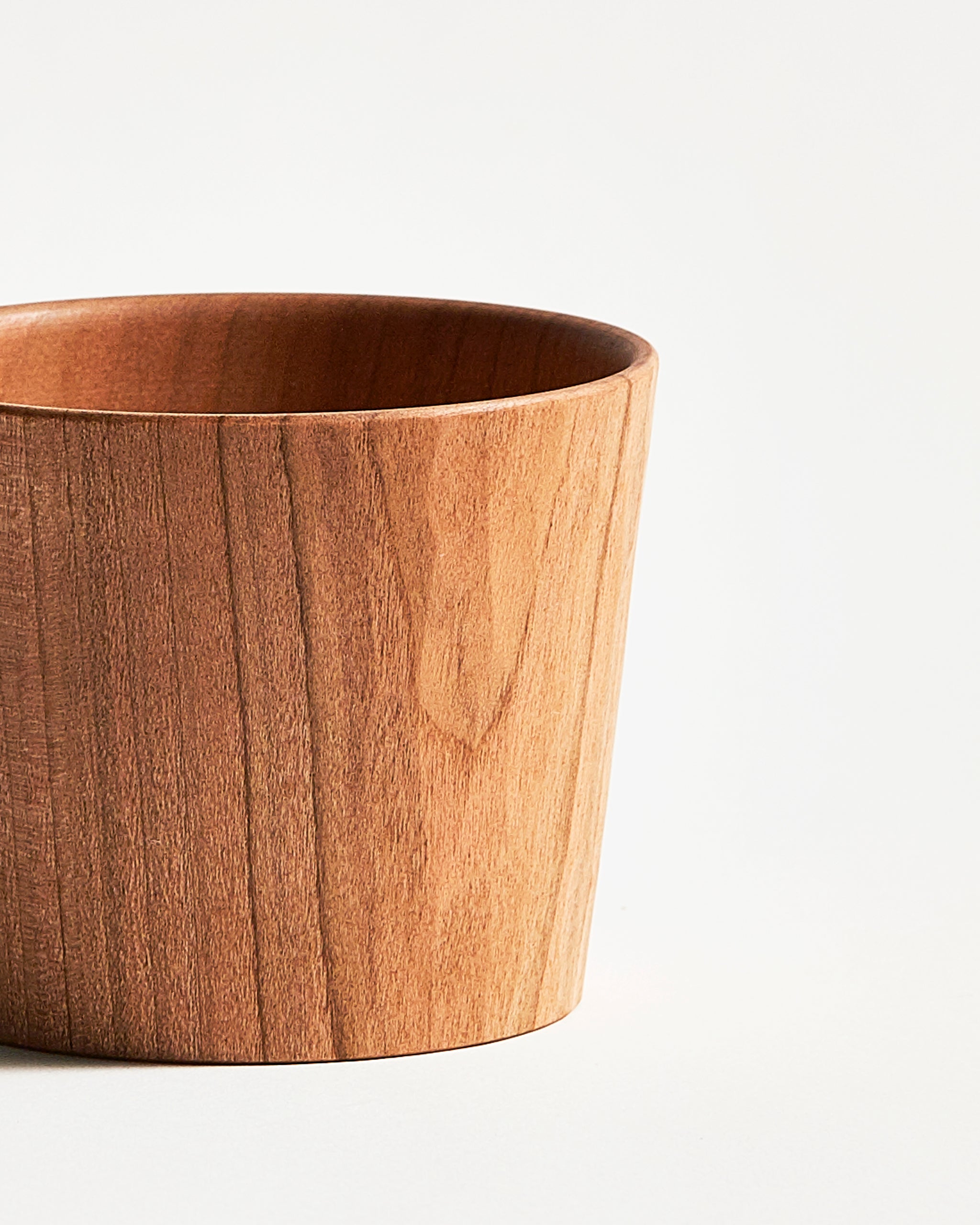 Up-close of wooden cup by Ryuji mitani on a light gray background