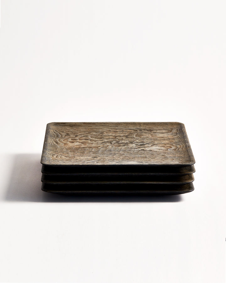 Front view of 4 stacked Usuzumi Square Plates with Chestnut Wood by Ryuji Mitani against white-gray background.