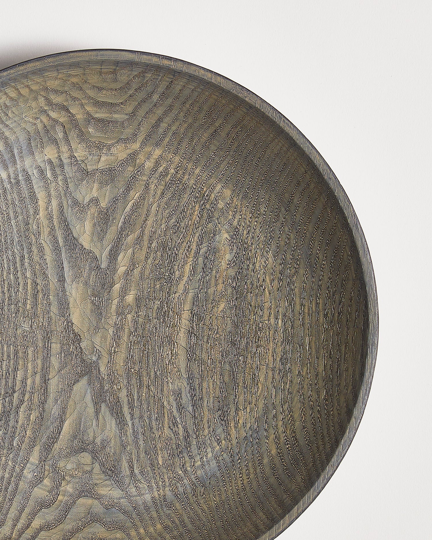 Close-up of a wooden bowl with a textured surface by Ryuji Mitani on a white background