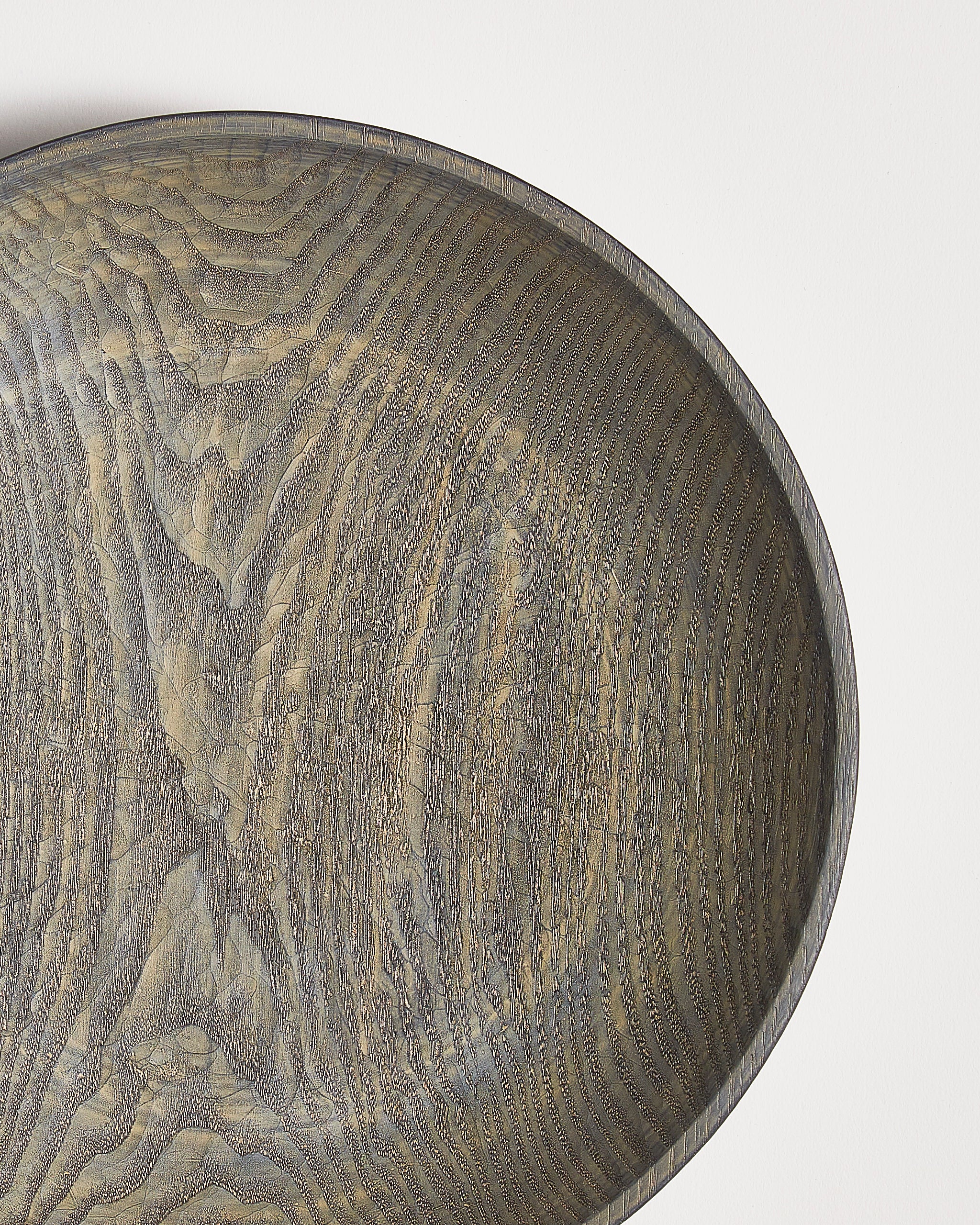 Close-up of a wooden bowl with a textured surface by Ryuji Mitani on a white background