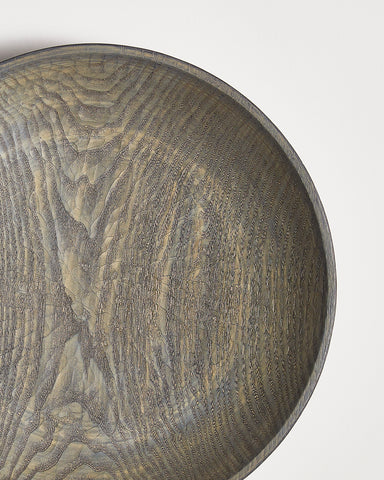 Close-up of a wooden bowl with a textured surface by Ryuji Mitani on a white background