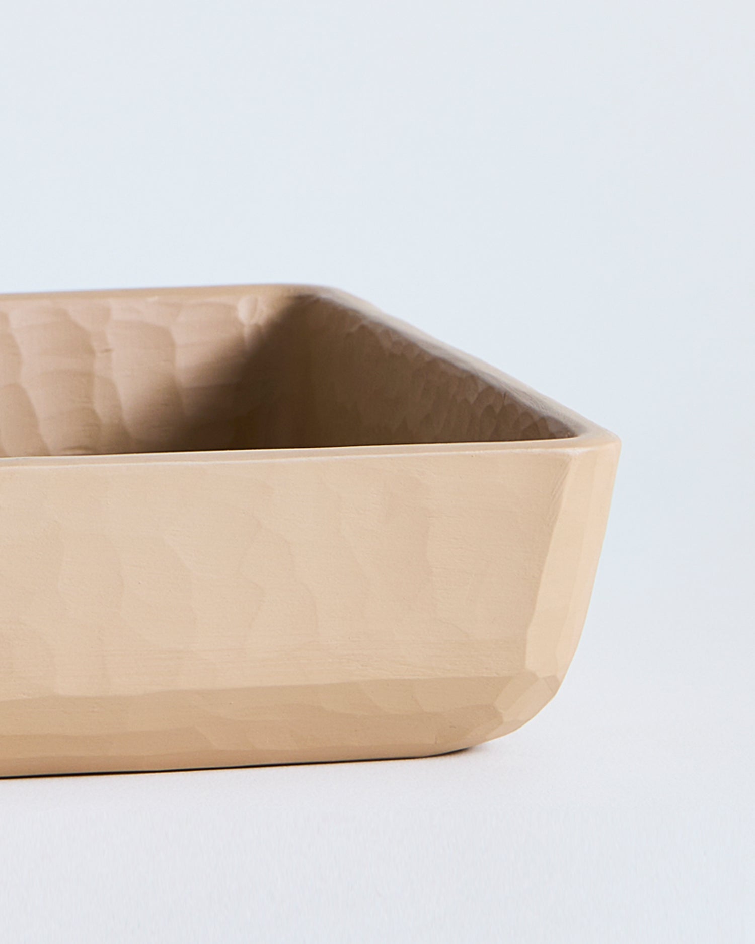 Beveled edge of a beige wooden square container by Ryuji Mitani on a light gray background