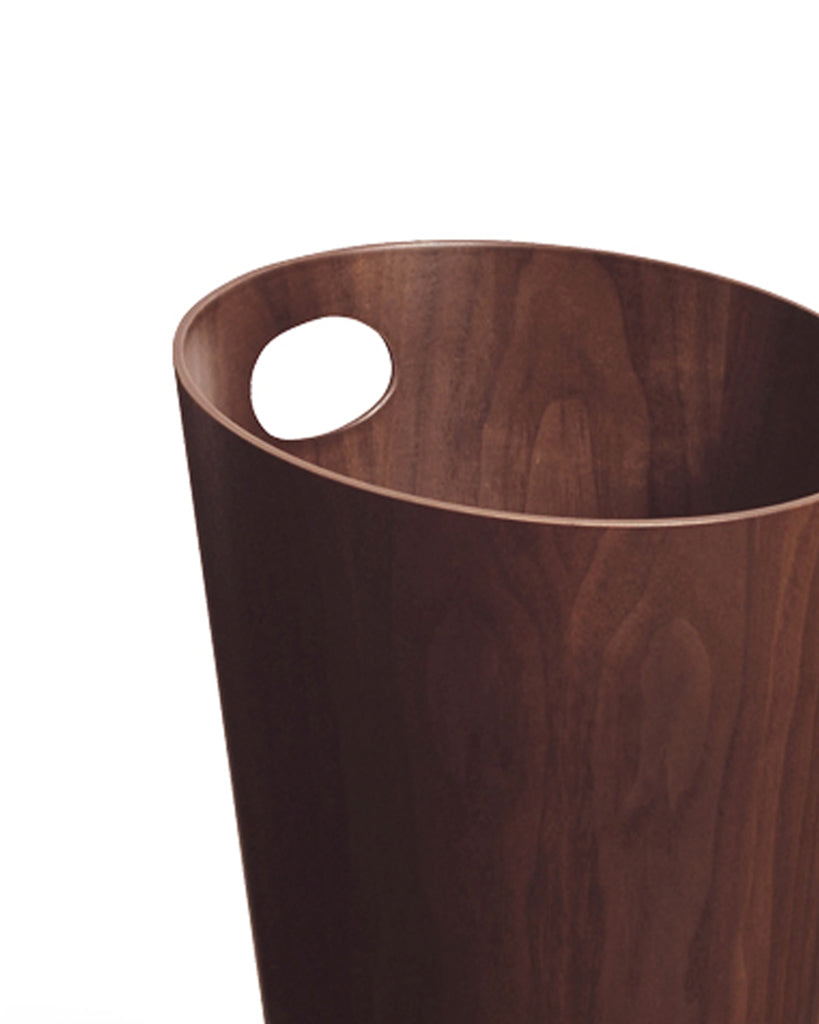 Cropped image focused on handle of walnut paper waste basket with handle by Isamu Saito against white background.