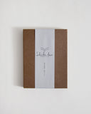 Brown outer packaging of notebook with a white label featuring 'Shiki-bun' on a light gray background