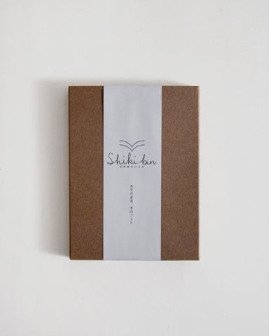 Brown outer packaging of notebook with a white label featuring 'Shiki-bun' on a light gray background