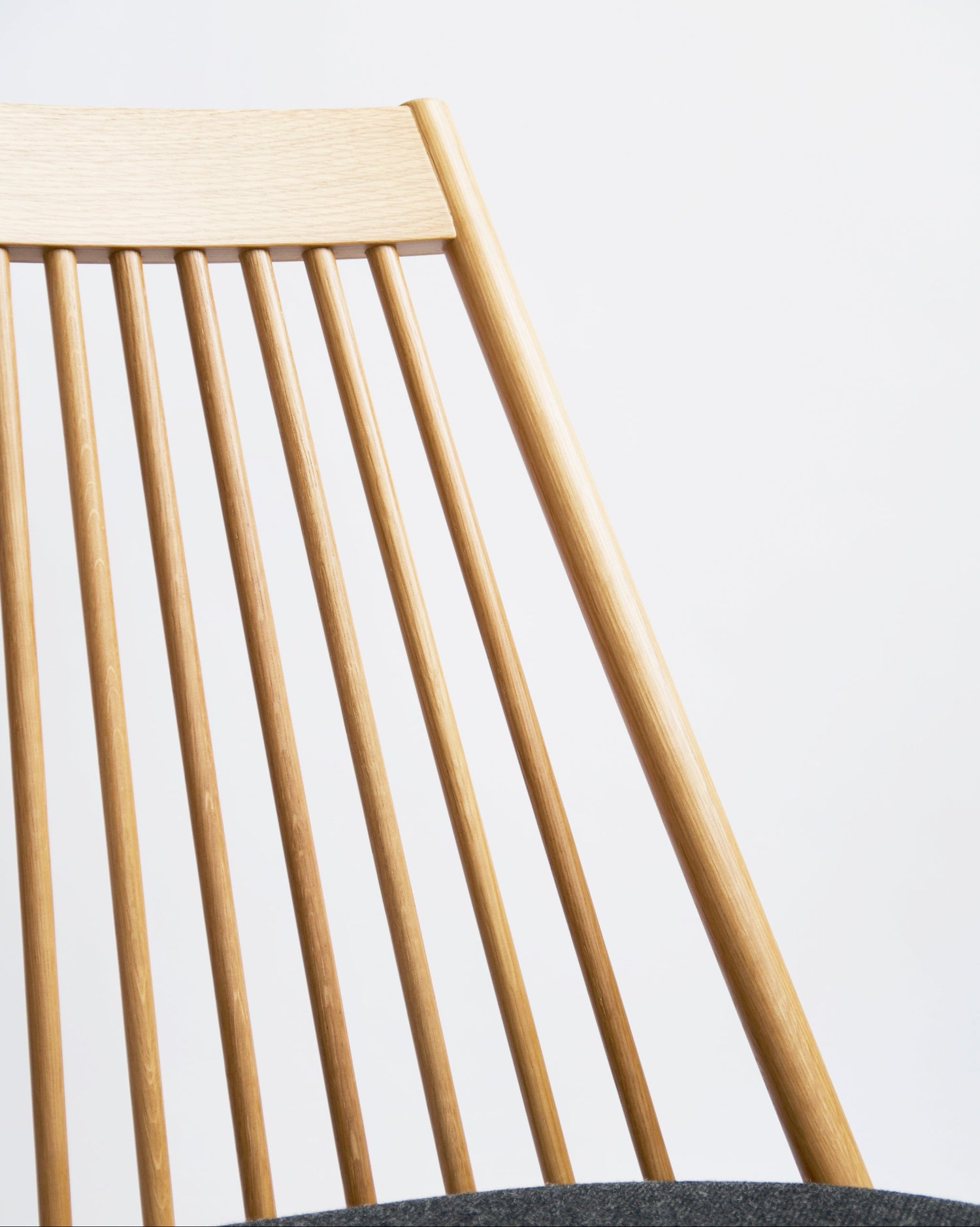 Close-up of a wooden chair by Tendo Mokko with slatted backrest on a light background