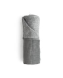 Hand size zen charcoal towel rolled up silhouetted against white background.