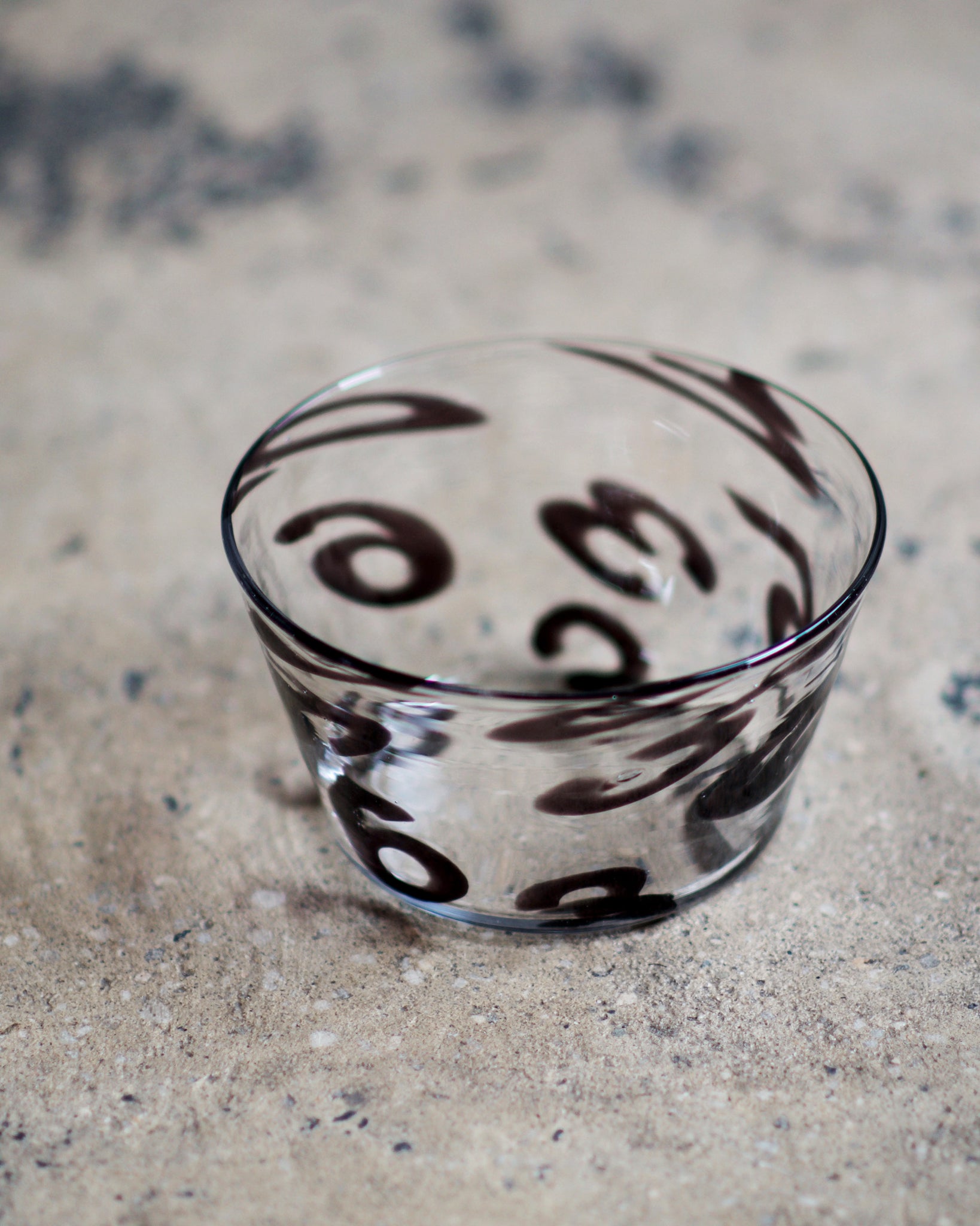365 bowl by factory zoomer is placed on a cement floor that is brown with gray textures.