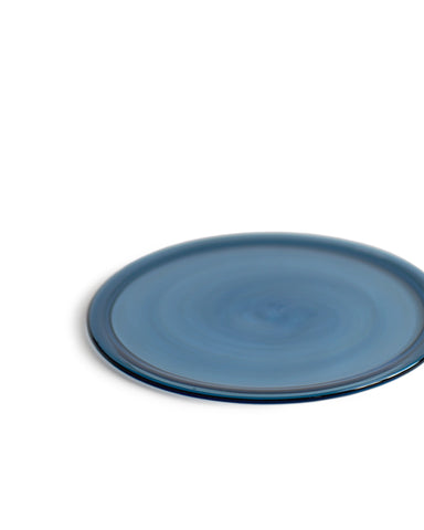 Silhouetted reclaimed blue folded rim plate in blue against white background. 
