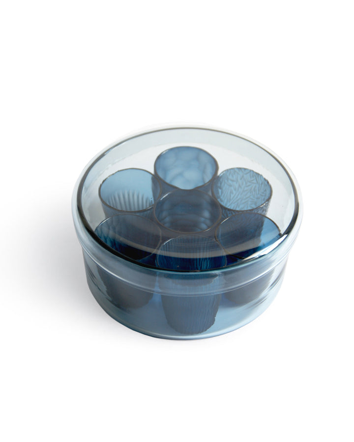 Angled top view of silhouetted reclaimed blue 'nature's diary' glass set against white background.