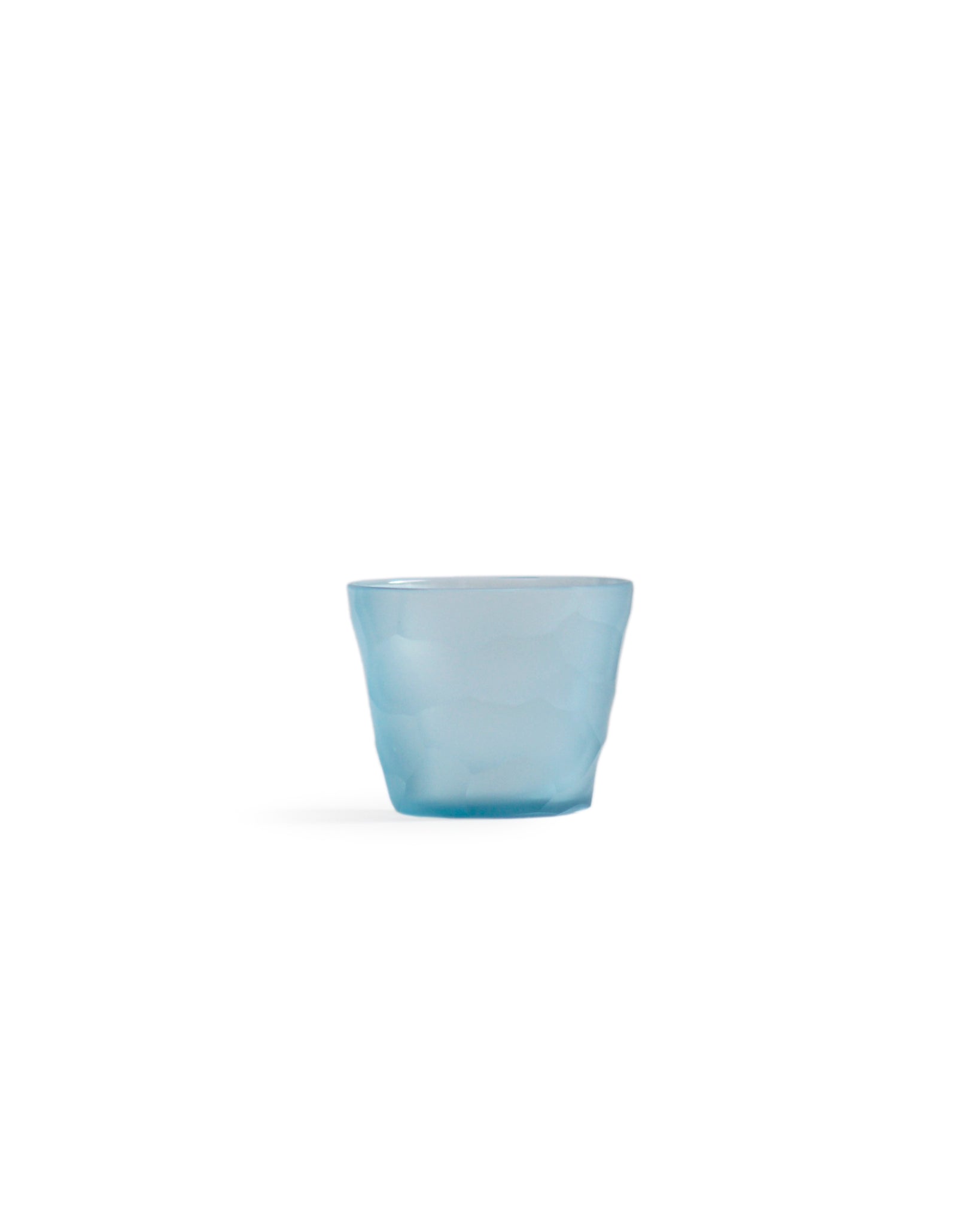 Silhouetted light blue reclaimed blue mini choko glass in rock pattern, against white background.