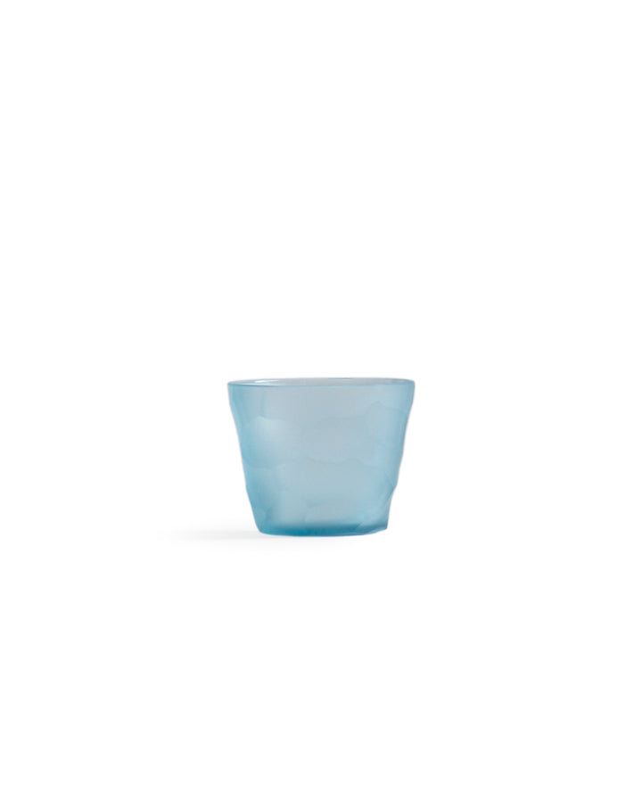 Silhouetted light blue reclaimed blue mini choko glass in rock pattern, against white background.