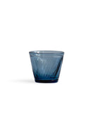 Silhouetted blue reclaimed blue whiskey glass against white background.