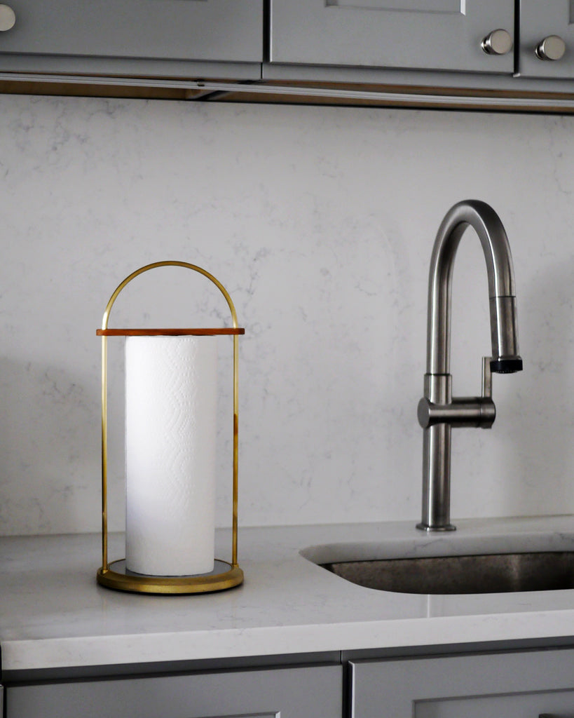 Futagami brass paper towel holder is placed on a granite kitchen countertop.