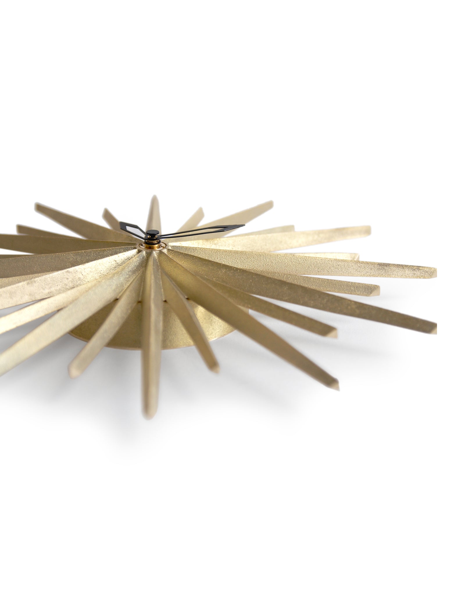 wall hanging brass starburst shape resting flat against white background