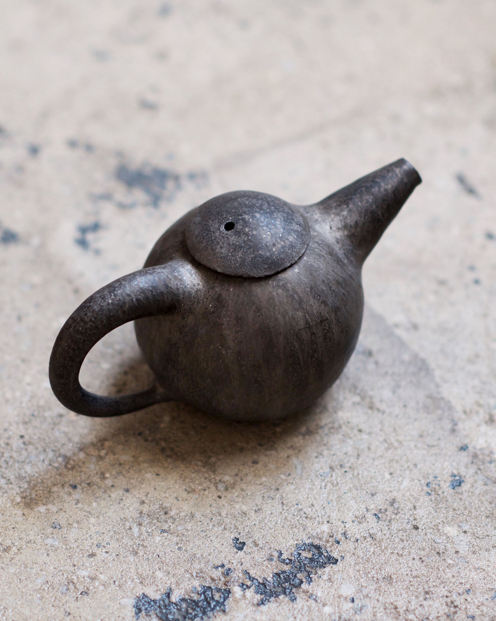 Black Teapot by Keisuke Iwata against concrete backdrop