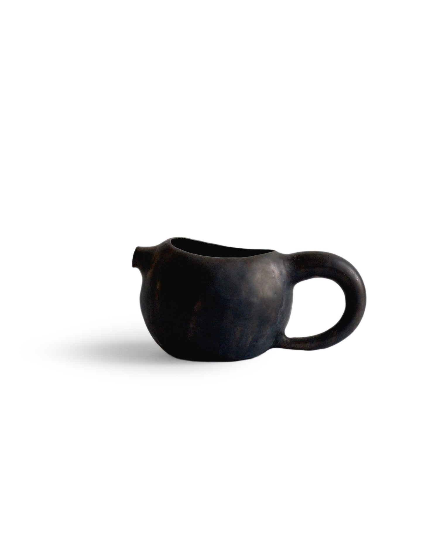 Silhouetted black katakuchi with handle against white background.