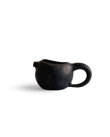 Silhouetted black katakuchi with handle against white background.