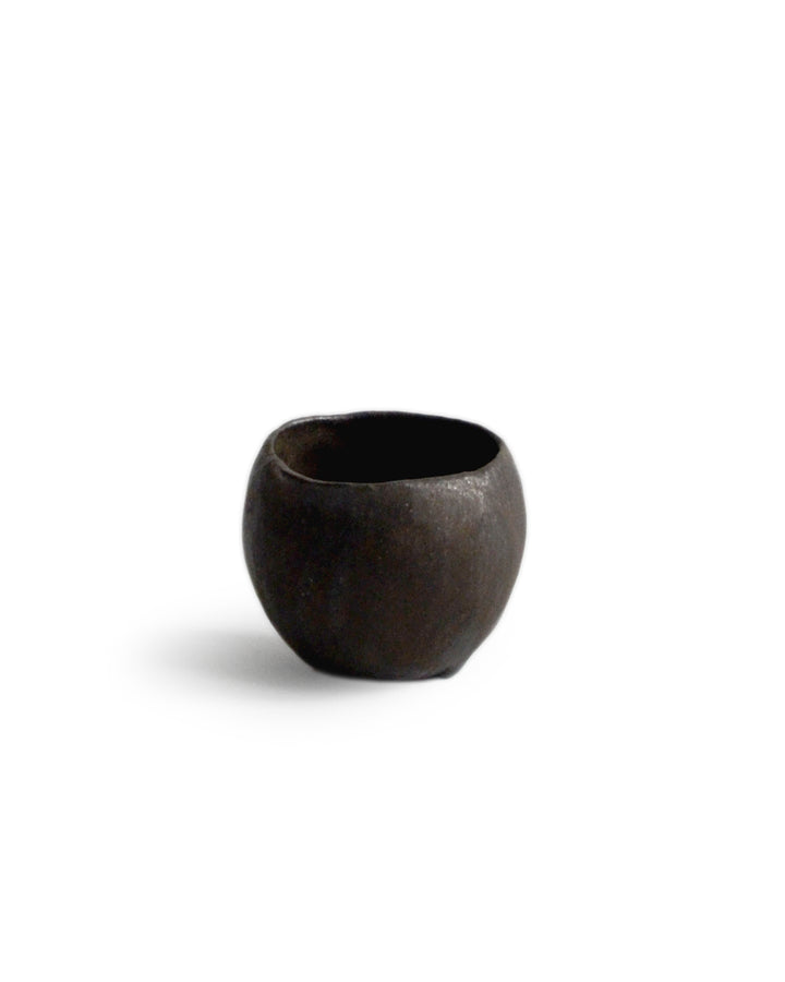 Round black ceramic pod cup handcrafted by Keisuke Iwata against white background