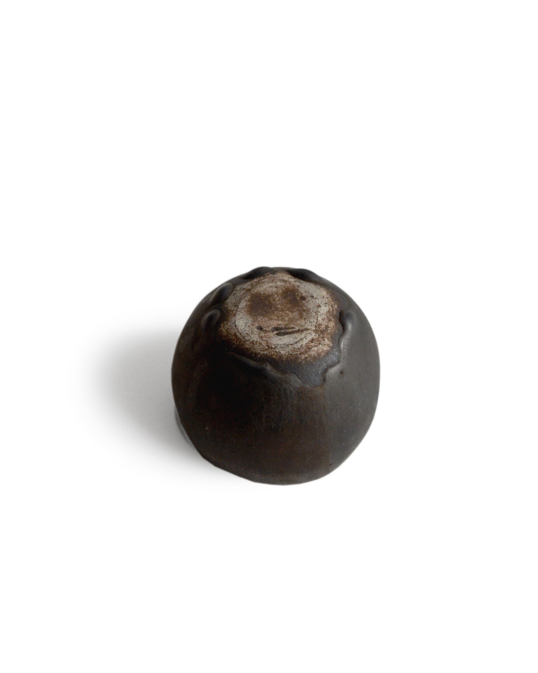 Round black ceramic pod cup handcrafted by Keisuke Iwata against white background