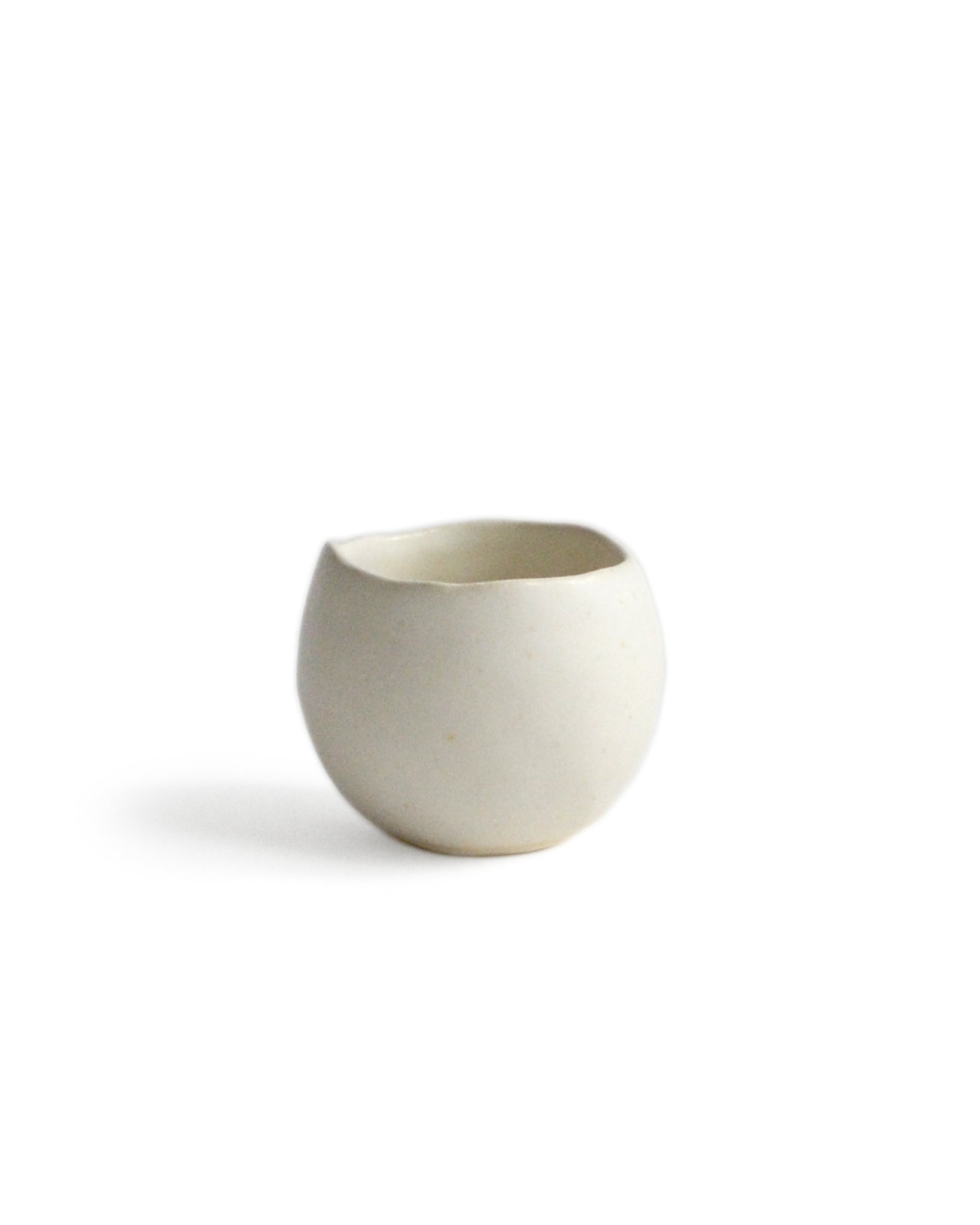 Round white ceramic cup handcrafted by Keisuke Iwata against white background