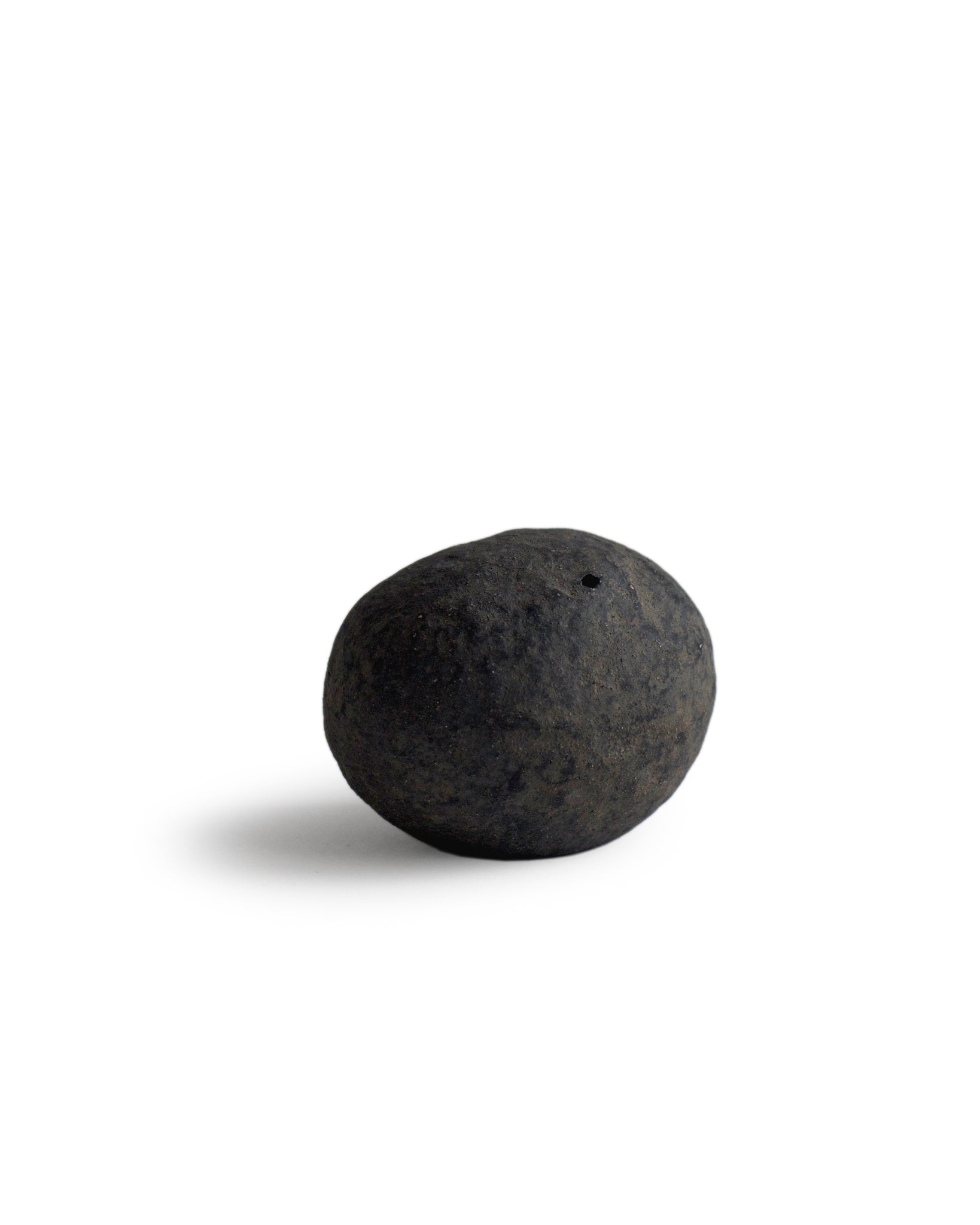 Handcrafted stone shaped vase by Keisuke Iwata silhouetted against white background