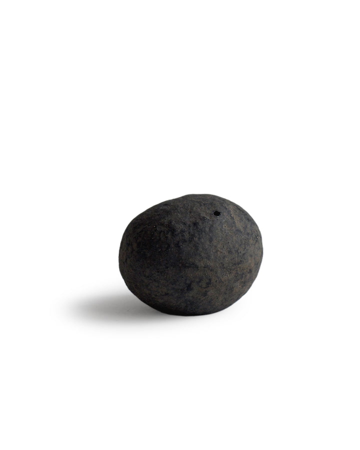 Handcrafted stone shaped vase by Keisuke Iwata silhouetted against white background
