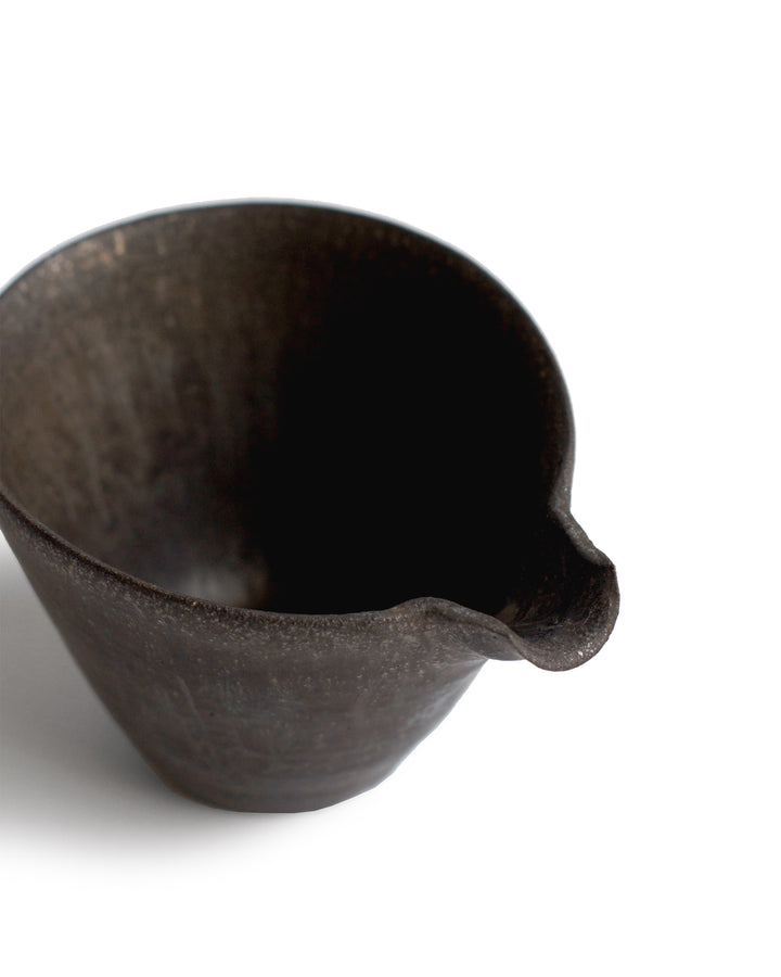 Silhouetted black tapered katakuchi against white background, focused on the spout detail.