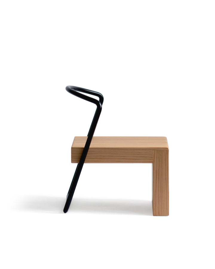 A side view of a silhouetted image of the Tetsubo Children's Chair against white background.