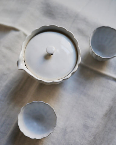Top down shot of chrysanthemum teapot and teacups by Masanobu Ando