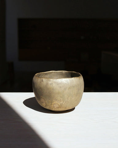 Gold Chawan II on a white oak table in a natural sunlight.