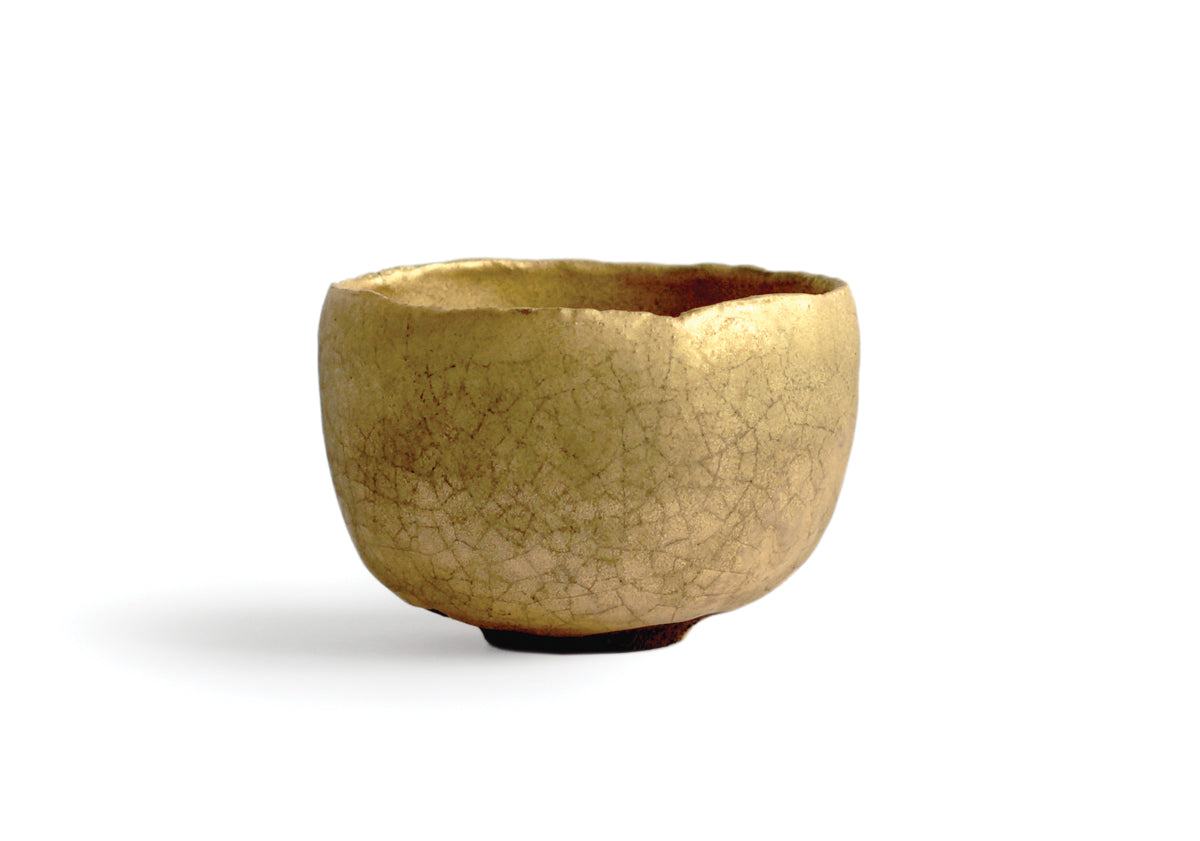 Gold Chawan XII silhouetted against white background.