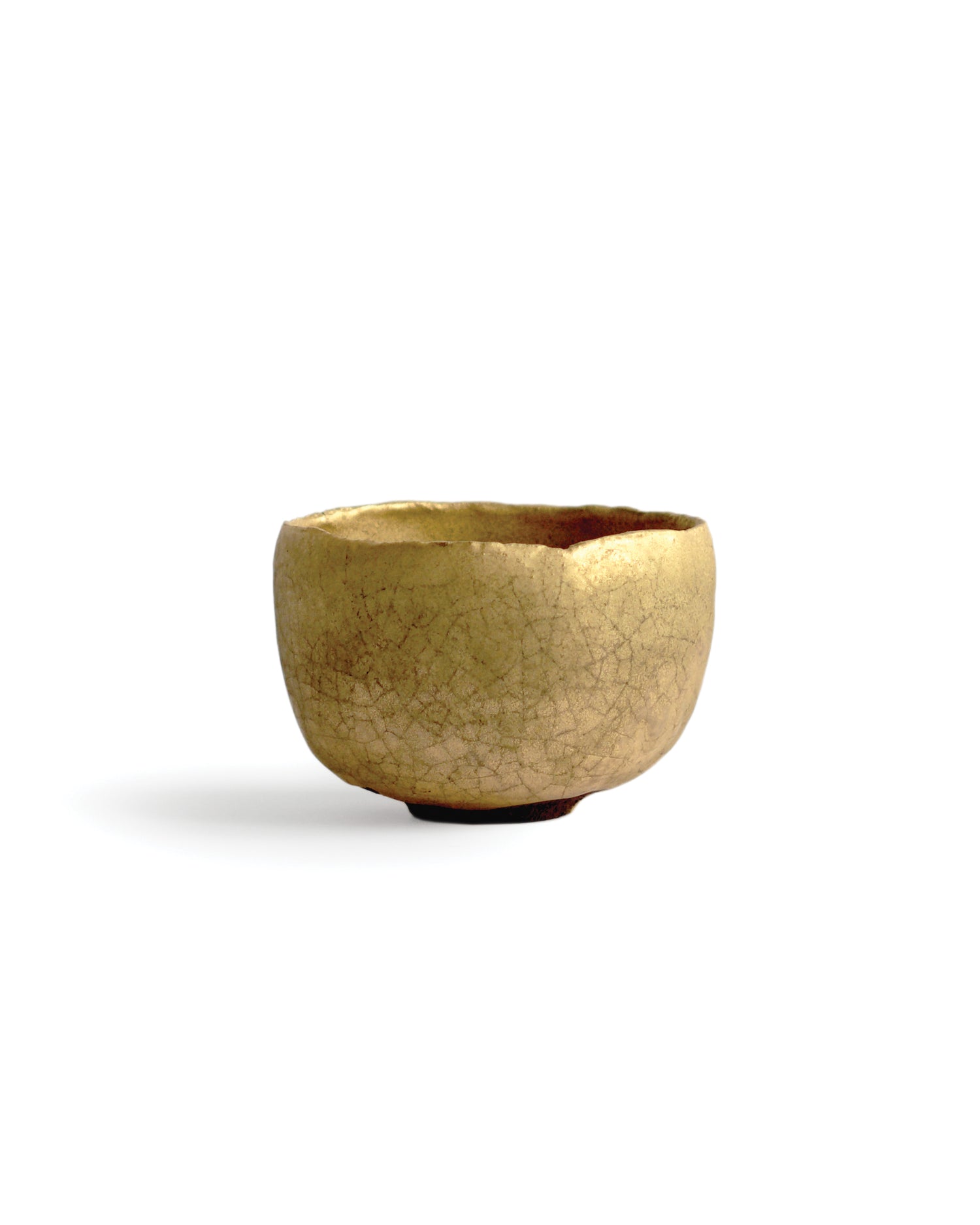 Gold Chawan XII silhouetted against white background.