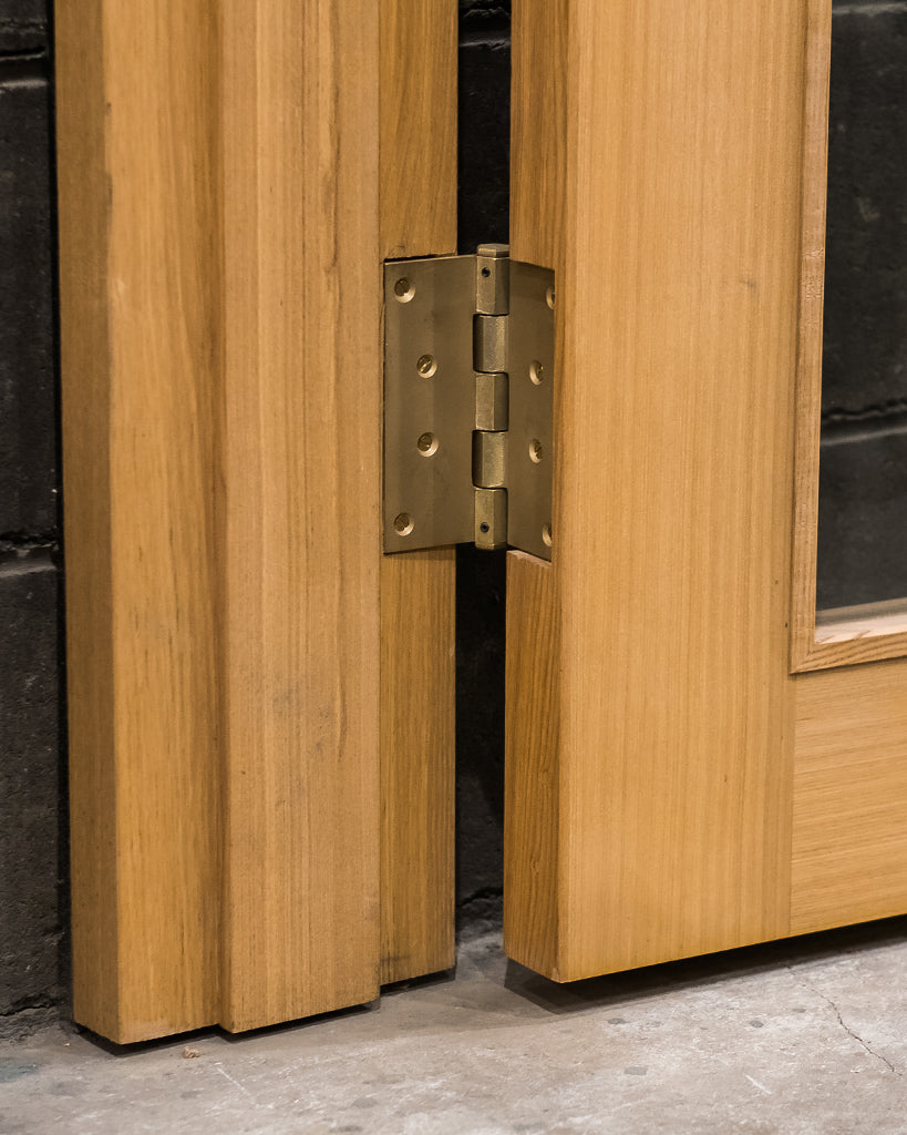 Matureware Brass Flat Hinge Large installed on wooden door with leaf showing