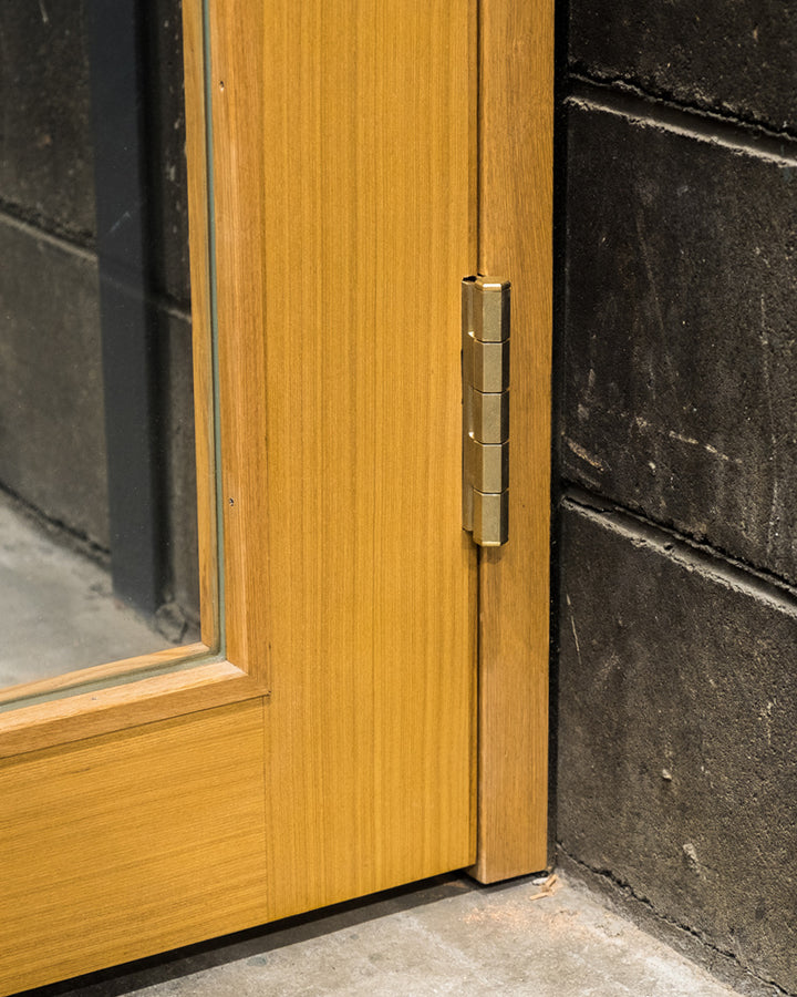 Matureware Brass Flat Hinge Large installed on closed wooden door