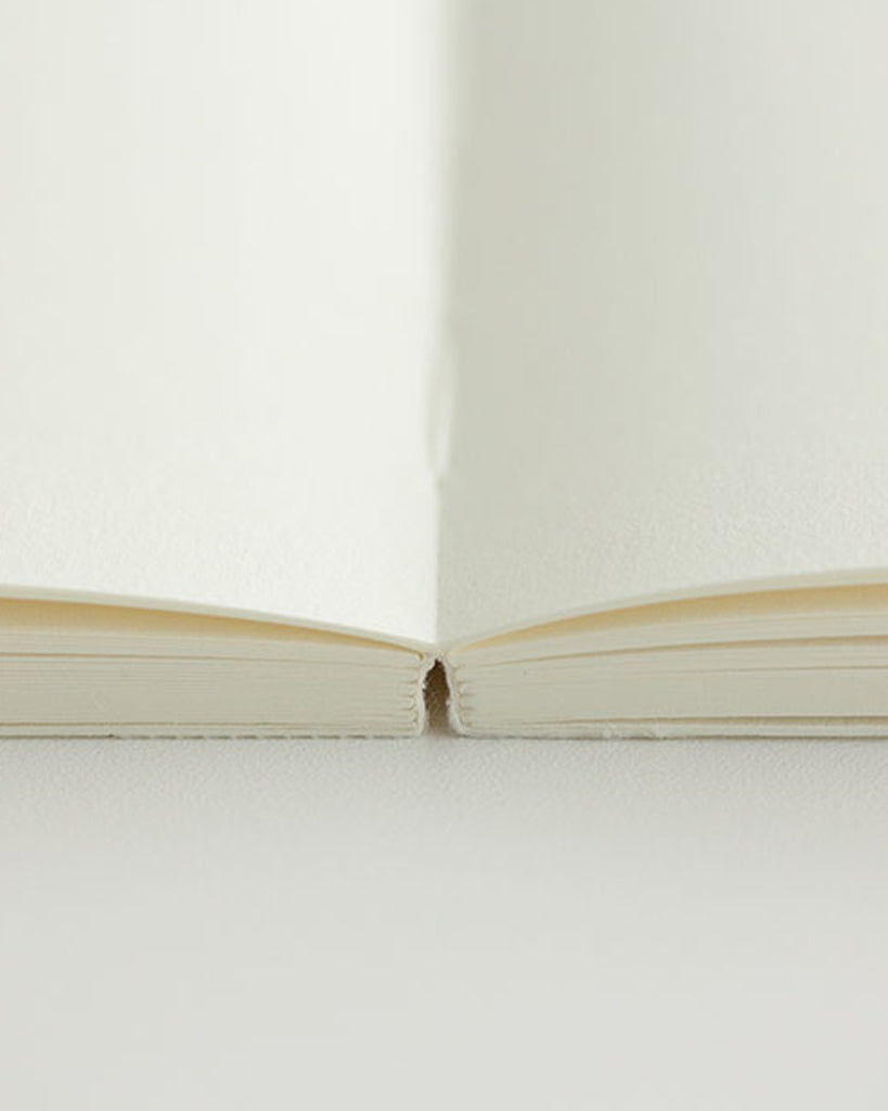 Cropped image focusing on the binding edge of the midori blank a5 notebook.