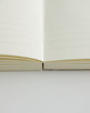 Cropped image focusing on the binding edge of the midori ruled a5 notebook.