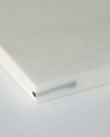 Detailed image of thread-stitched book-binding from the exterior of the notebook.