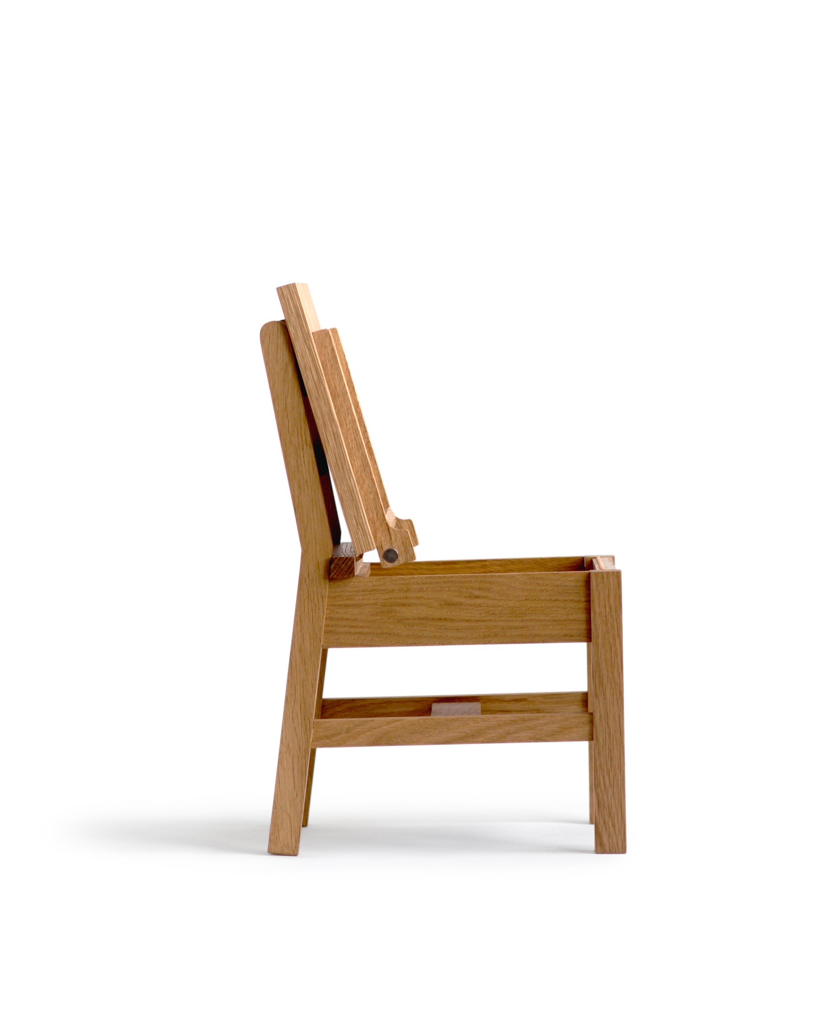 A side view of a silhouetted image of the Keepsake Kids Chair with its seat lid open on a white background.