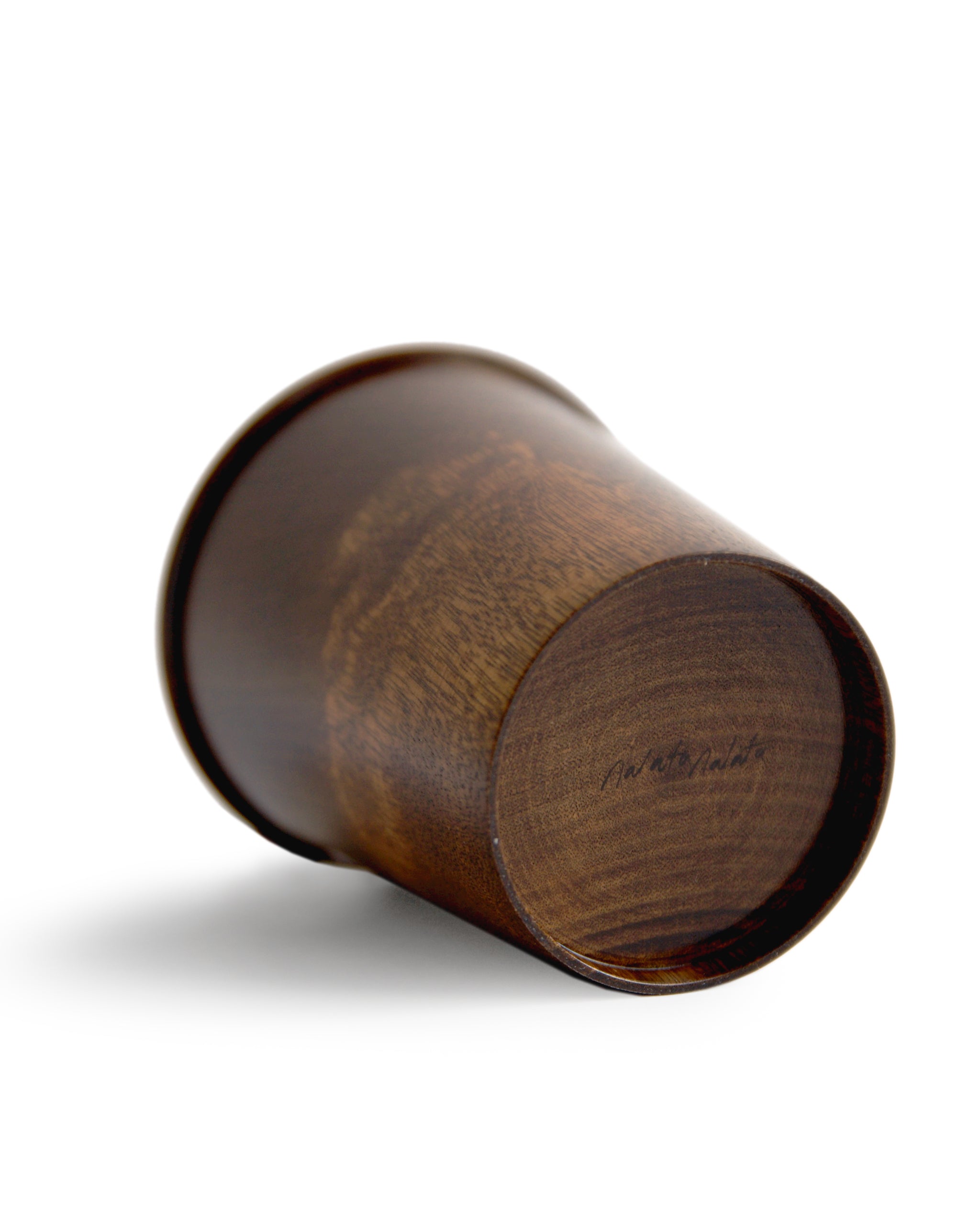 View of the bottom of the brown urushi wood cup showing the nalata nalata logo.