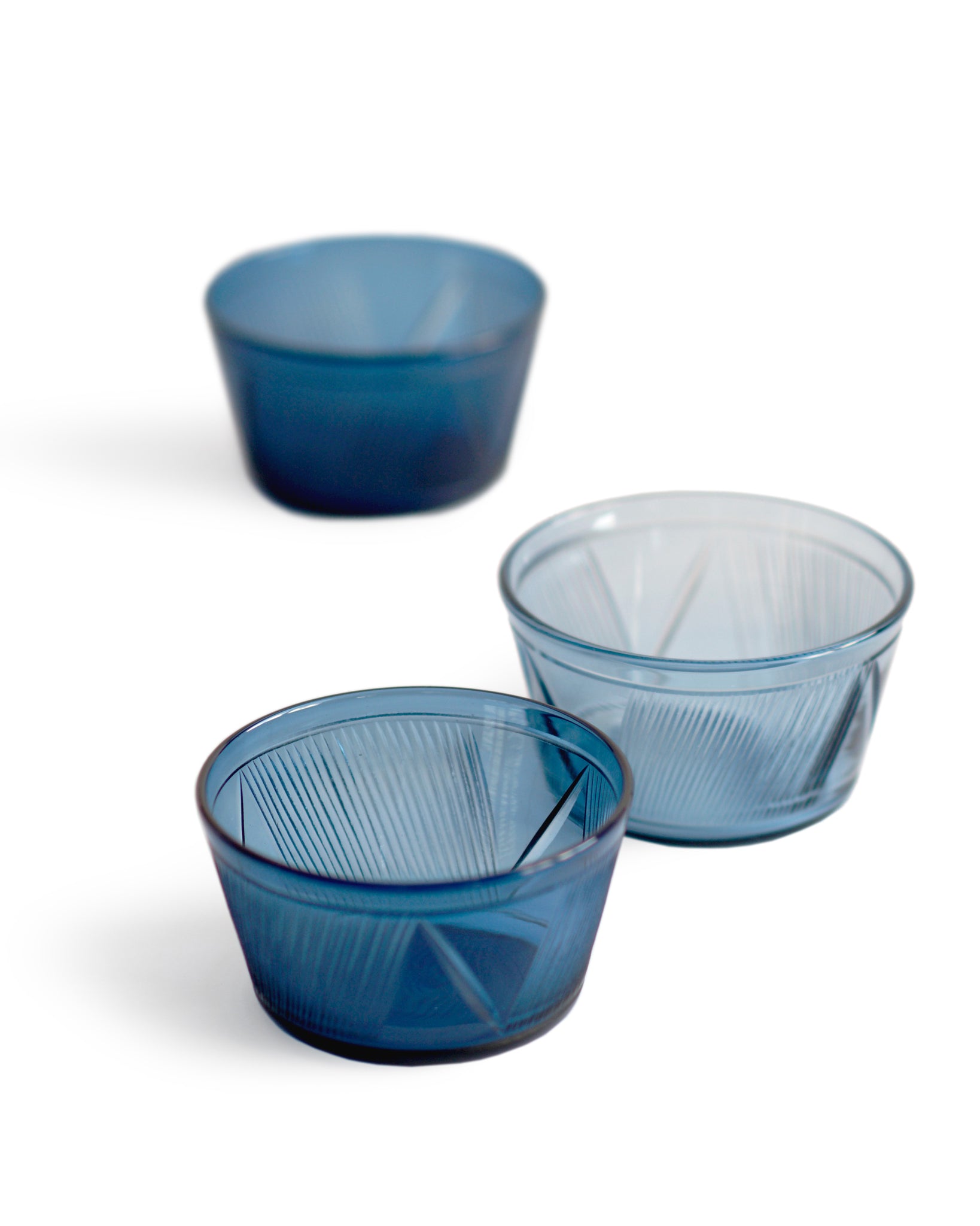 Three reclaimed blue bowls in a row featuring different shades of blue. The dark blue bowl in the front is in focus.