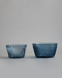 Small and large reclaimed blue bowl placed next to each other. Small bowl the left is of lighter blue than the large bowl on the right. 