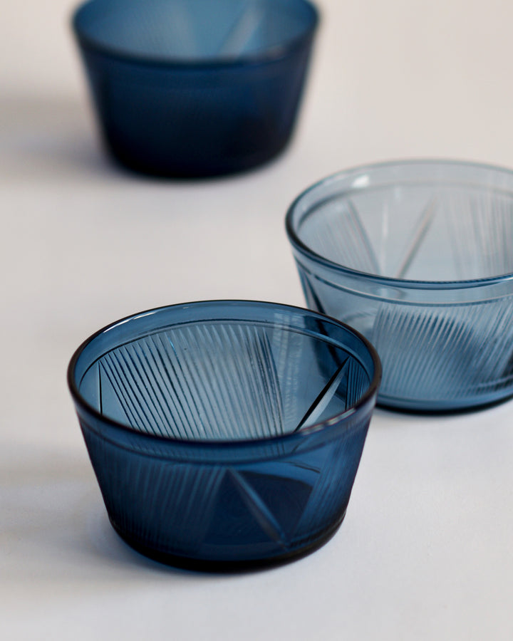Three reclaimed blue bowls in a row featuring different shades of blue. The dark blue bowl in the front is in focus.
