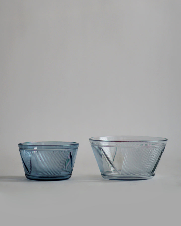 Small and large reclaimed blue bowl placed next to each other. Small bowl on the left is of darker shade of blue than the large bowl on the right.